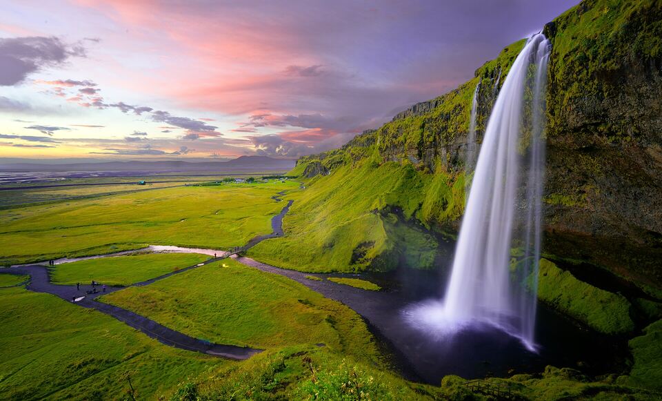 Seljalandsfoss waterfall in Iceland at sunset, as the sliders beside it change it