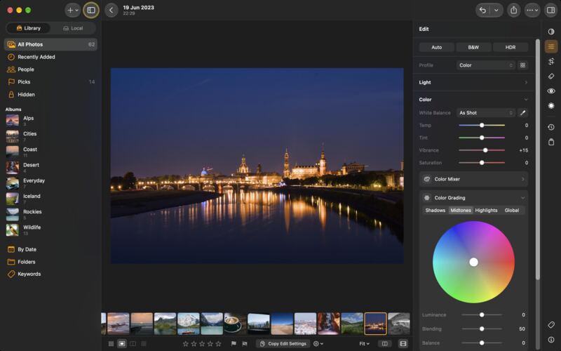 LightBites en un Mac editant una foto nocturna d'una ciutat vora un riu: la roda de Color Grading al costat